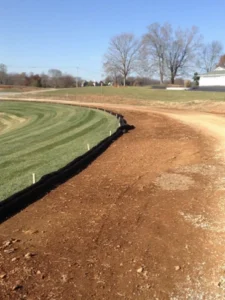 Image of a silt fence installed for erosion control and sediment management at an Apex Environmental waste disposal site.