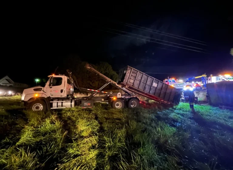 Image of a large dumpster in a field used for waste removal and disposal, available for rental from Apex Environmental.